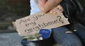 A beggar holding a sign that says 