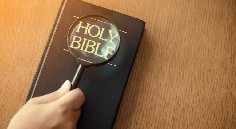 A bible being examined with a magnifying glass