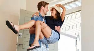 Husband brings laughing bride into the house